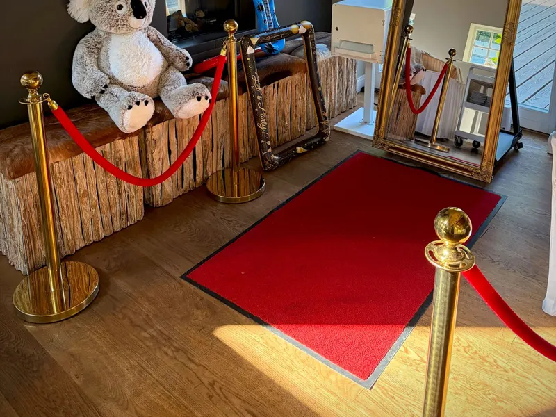 Magic Mirror mit rotem Teppich und Absperrkordeln am Kamin der Scheune St. Georg in Rastede